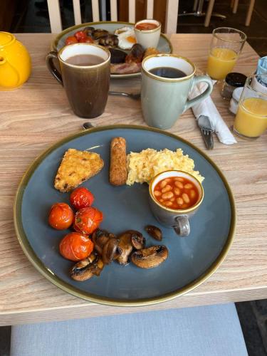 a table with a blue plate of food and coffee at Old Manor House in Axbridge