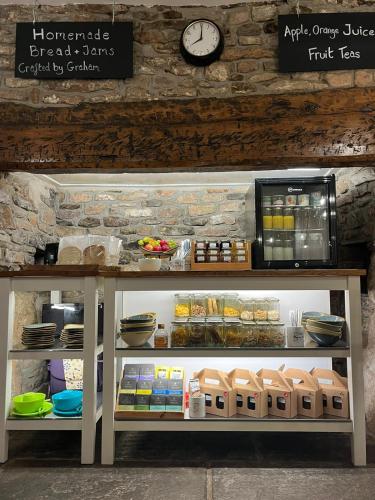 a counter with a refrigerator with food and a clock at Old Manor House in Axbridge