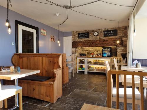 un ristorante con pareti e tavoli in legno e sedie di Old Manor House ad Axbridge