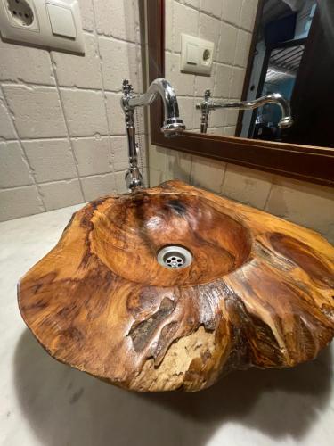 a wooden bathroom sink made out of a log at Can Canaleta Hotel Rural in Santa Coloma de Farners