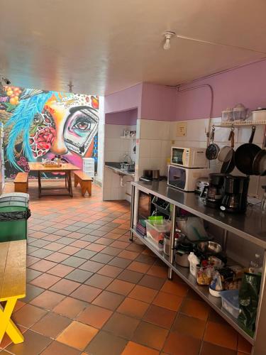 a kitchen with a large painting on the wall at Yolo Hostel Medellin in Medellín