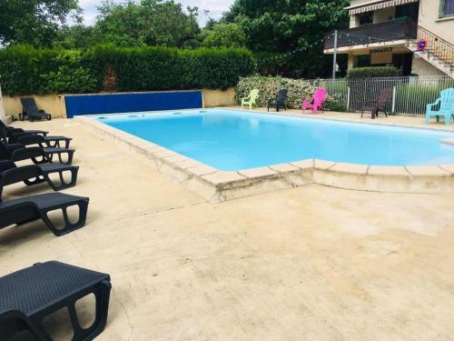 duży basen z krzesłami wokół niego w obiekcie Camping des Cigales w mieście Aiguèze