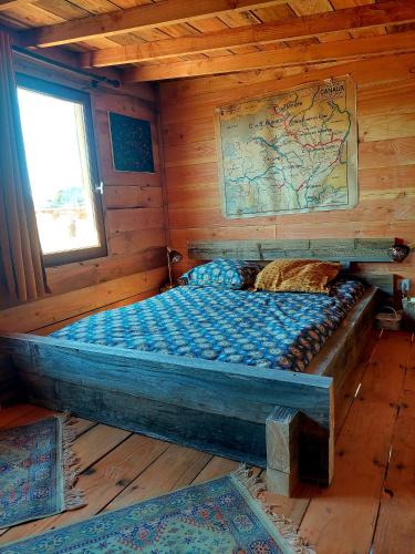 a bedroom with a bed in a wooden cabin at Cabane insolite TOUT CONFORT Chalet Gites Luzy Morvan Bourgogne in Luzy