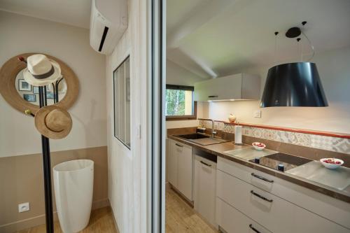 d'une cuisine avec des placards blancs et un plafond noir. dans l'établissement Salamandre et Hippocampe, à Lanton