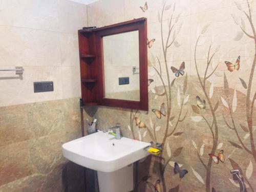 a bathroom with a sink and a mirror at Happy Three Holiday Homes in Hikkaduwa