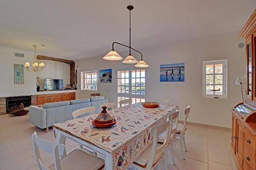 a kitchen and living room with a table and chairs at Casa de Apra by Portucasa in Loulé