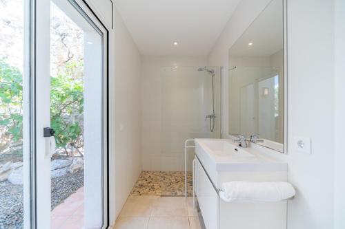 y baño con lavabo blanco y espejo. en Villa Isabelle, en L'Escala