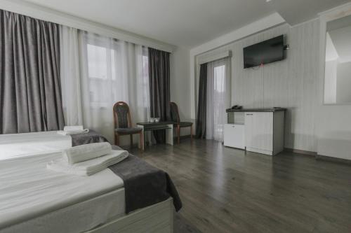 a hotel room with a bed and a television at Hotel Apollo Central in Sibiu