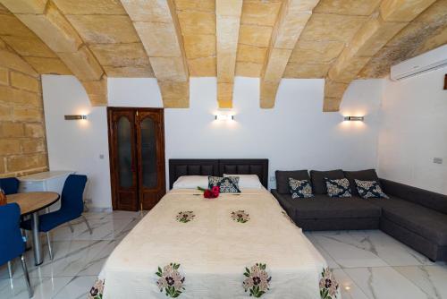 a bedroom with a large bed and a couch at Valletta Old Well Apartments in Valletta