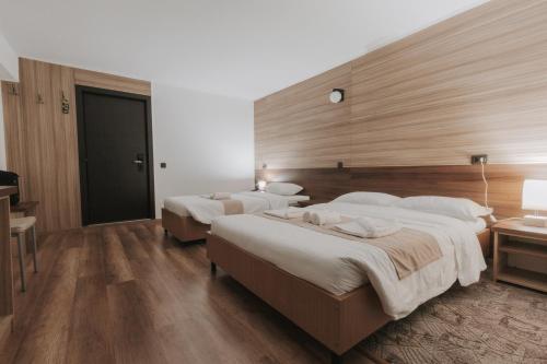 a hotel room with two beds and a desk at Hotel Apollo Central in Sibiu