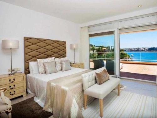 a bedroom with a large bed and a large window at VILLA LANTANA Lujo y estilo con vistas únicas al puerto de Mahón in Cala Llonga