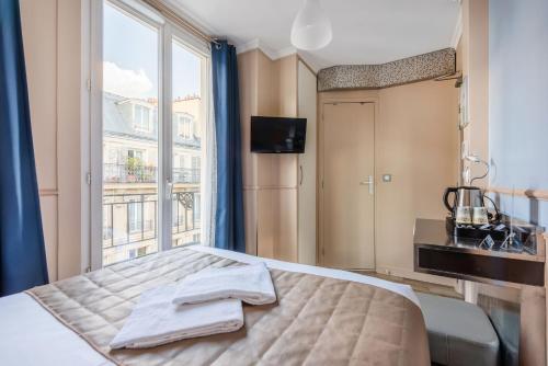 um quarto com uma cama e uma grande janela em District Republique em Paris