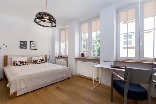um quarto com uma cama, uma secretária e janelas em Hello Apartments Modena Sw Ducha em Gdansk