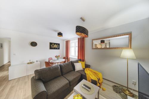 a living room with a couch and a mirror at Tower Apartments in Spišská Nová Ves