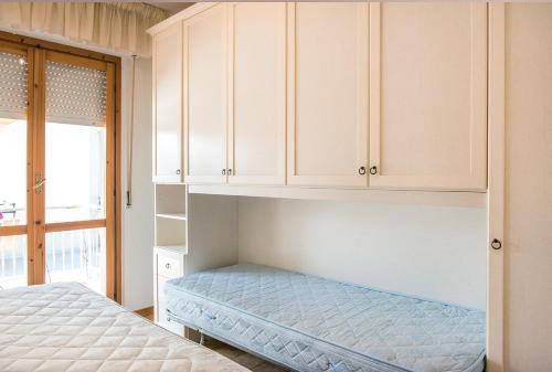 a bedroom with a bed and white cabinets at M033 - Marcelli, trilocale in centro fronte mare in Marcelli