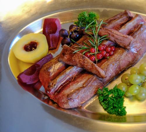 a plate of food with meat and fruit on it at Hotel Bellevue in San Bernardino