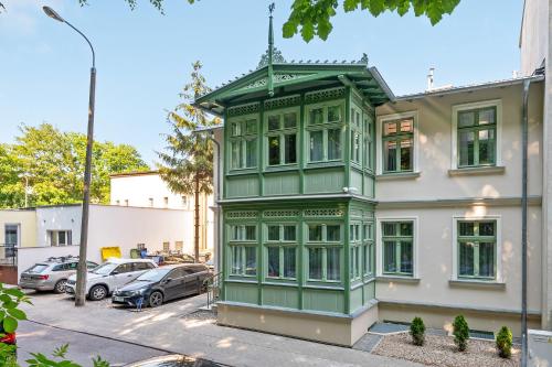 a green building on the side of a street at Royal Apartments - Winieckiego in Sopot