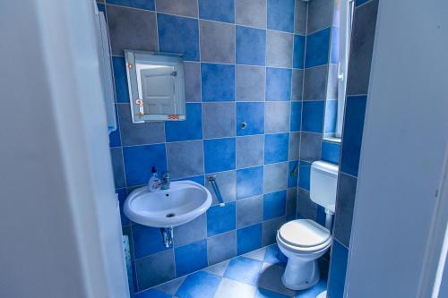 a blue tiled bathroom with a toilet and a sink at Prenočišče Maribor Center in Maribor