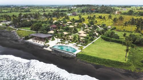 an aerial view of a resort next to the ocean at Bali Beach Glamping in Tabanan