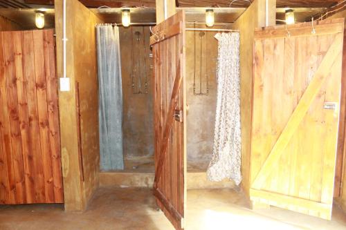 um quarto com paredes e portas de madeira em The Joint Backpackers em Oudtshoorn