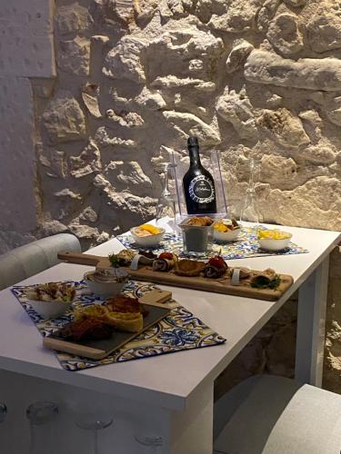 stół z jedzeniem i butelką wina w obiekcie SiricyAus Luxury Room w mieście Ragusa