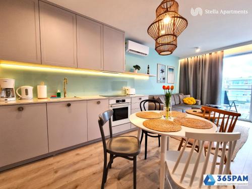 a kitchen and dining room with a table and chairs at Apartamenty w Gąskach - 365PAM in Gąski