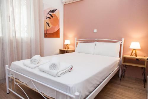 a bedroom with a white bed with towels on it at Beautiful new apartment in Petralona in Athens