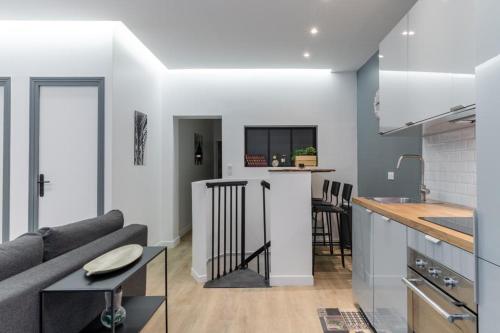 une cuisine et un salon avec un canapé et une table dans l'établissement HSH Batignolles Sauffroy Charming Apartment 8P, à Paris