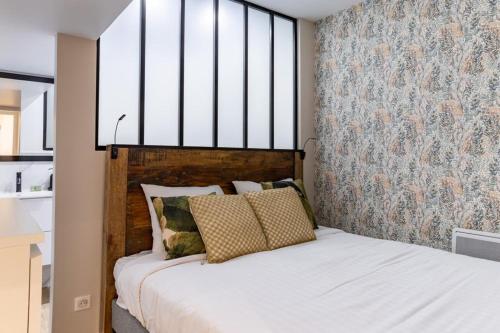 une chambre avec un lit avec une grande fenêtre dans l'établissement HSH Batignolles Sauffroy Charming Apartment 8P, à Paris