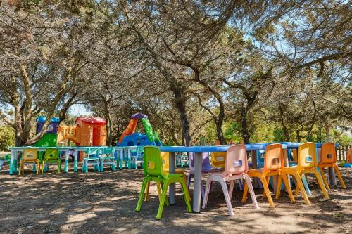 a row of tables and chairs at a playground at Club Esse Roccaruja in Stintino