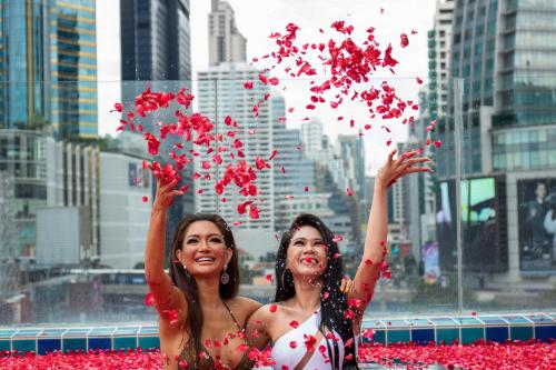 two women in bathing suits are playing in a fountain at Hotel Clover Asoke - SHA Extra Plus in Bangkok