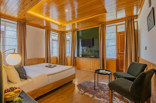 a bedroom with a bed and a chair in a room at Lost in the Alps by VEO - Part of StayVista in Manāli