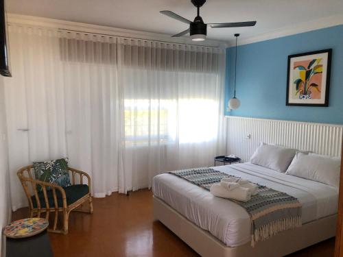 a bedroom with a large bed and a window at Paradise Motel Busselton in Busselton