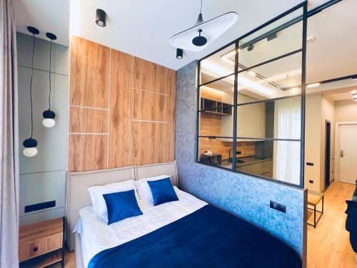 a bedroom with a bed with a blue accent wall at New Gudauri Premium Apartments NEO in Gudauri