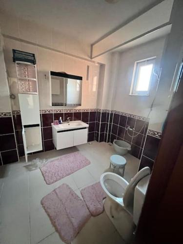 y baño con lavabo, aseo y espejo. en Şehir Manzaralı Büyük Bahçeli Villa 