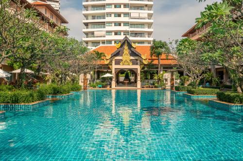 a swimming pool in a resort with a tall building at Avalon Beach Resort in Pattaya South