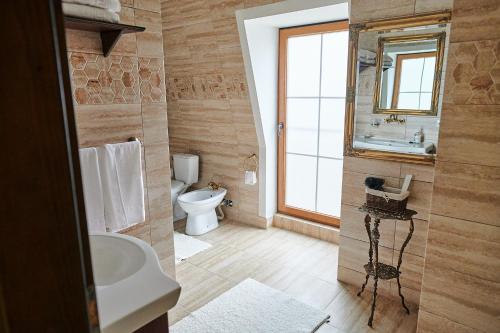a bathroom with a sink and a toilet and a mirror at Saciova Hills in Saciova