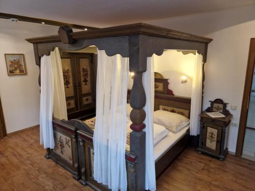 a bedroom with a canopy bed with white curtains at Gasthof Post in Mittersill