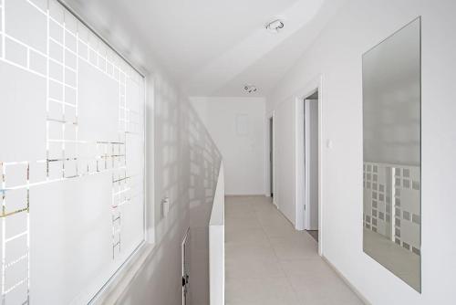 un corridoio con pareti in piastrelle bianche e un corridoio con porta di Luxury Villa Tina Moseni with private heated pool a Kaštela (Castelli)