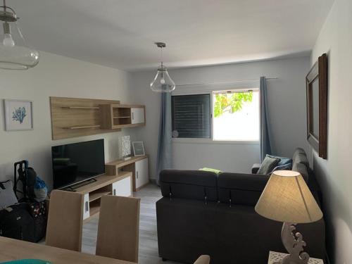 salon z czarną kanapą i telewizorem w obiekcie Fabulous Villa Mabel w Corralejo