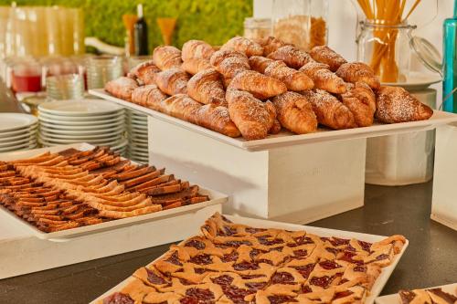 a buffet with trays of pastries and pastries at Club Esse Roccaruja in Stintino