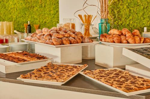 a buffet filled with different types of pastries and bread at Club Esse Roccaruja in Stintino