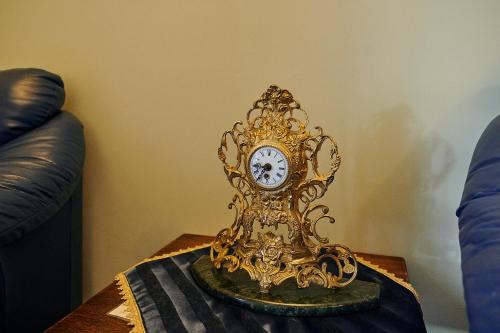 a gold clock sitting on top of a table at Saciova Hills in Saciova