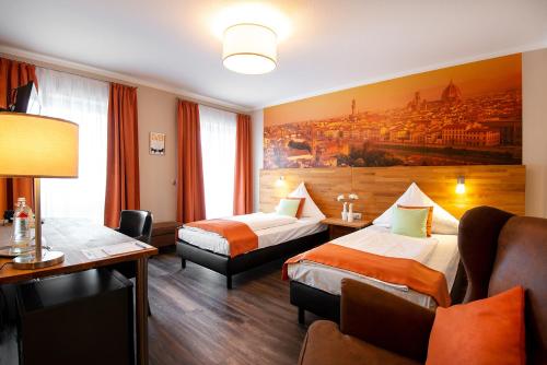 ガイレンキルヒェンにあるCity Hotelのベッド2台とソファが備わるホテルルームです。