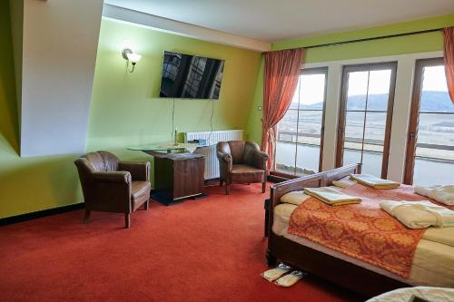 a hotel room with a bed and a desk and chairs at Saciova Hills in Saciova