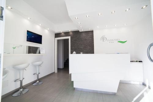 una camera bianca con bancone e sgabelli di B&b Diamond a San Vito lo Capo