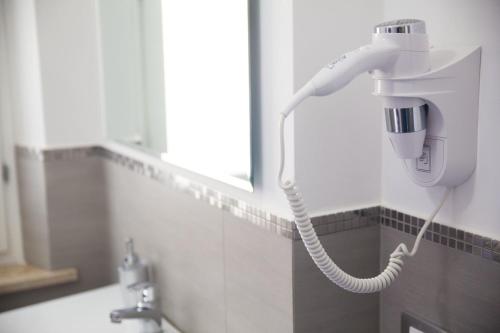 a blow dryer on the wall of a bathroom at B&b Diamond in San Vito lo Capo
