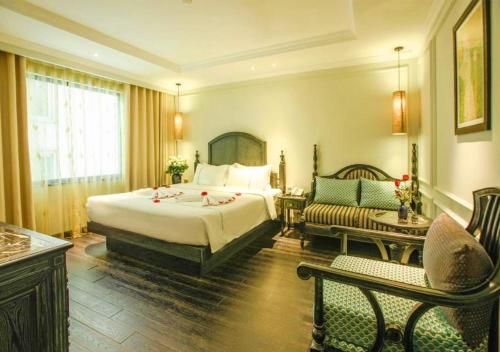 ein Hotelzimmer mit einem großen Bett und einem Sofa in der Unterkunft Hanoi Emerald Waters Hotel Valley in Hanoi