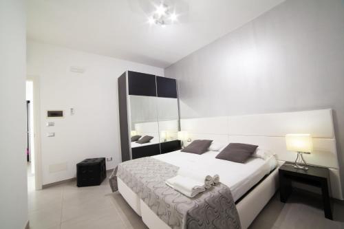 una camera bianca con letto e specchio di B&b Diamond a San Vito lo Capo