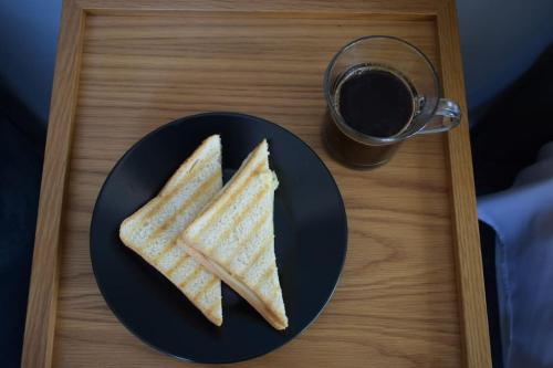 two sandwiches on a plate next to a cup of coffee at Acropolis View Apartment Athens Downtown in Athens